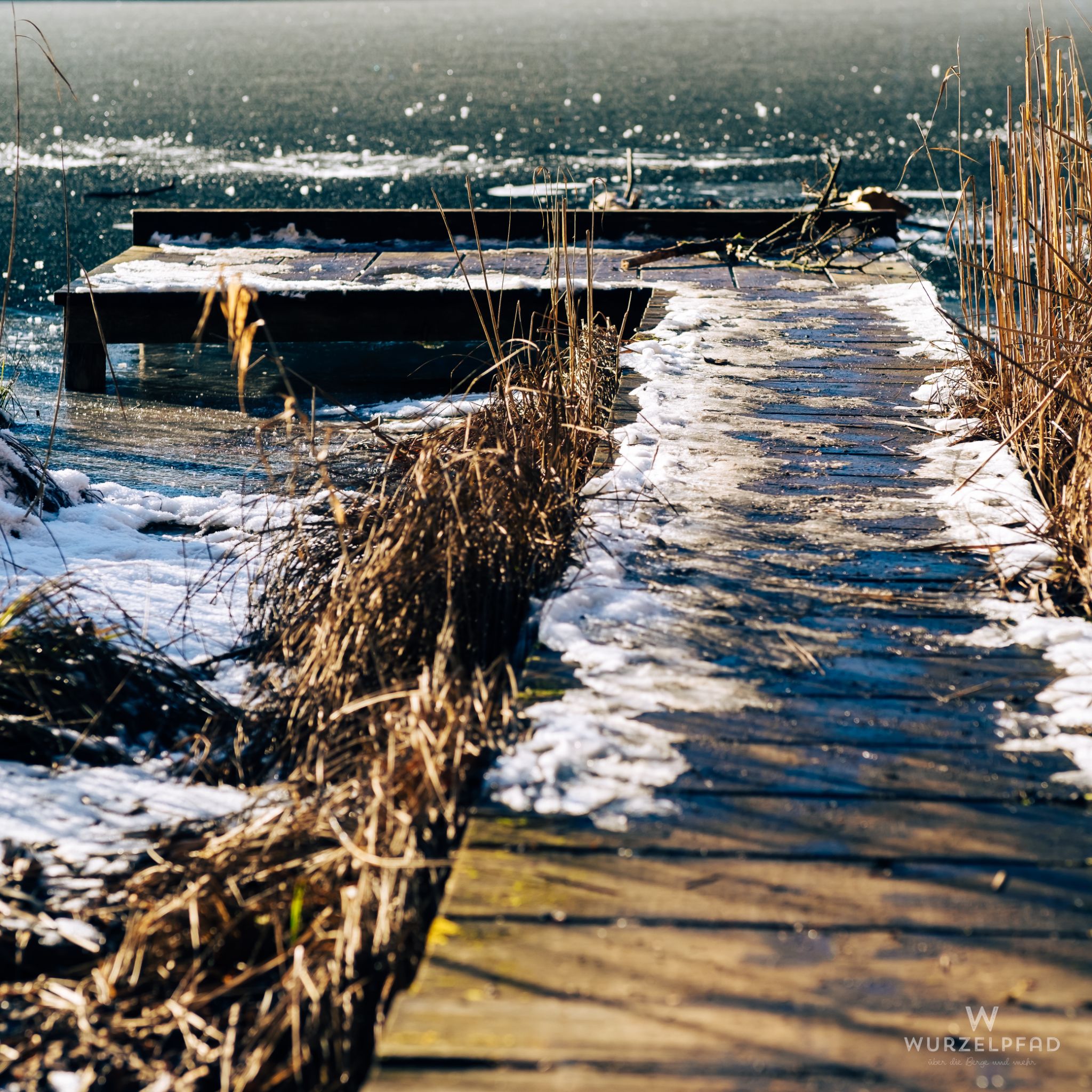 Frozen lake, wooden pier, winter scene.
